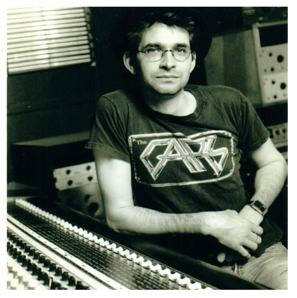 Black-and-white photo of Steve Albini wearing a band T-shirt, seated at a mixing console